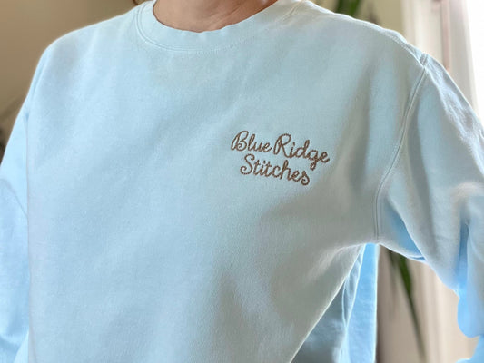 a woman is wearing a blue ridge sweater