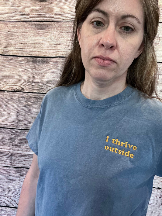 a woman wearing a blue t - shirt with i drive outside on it